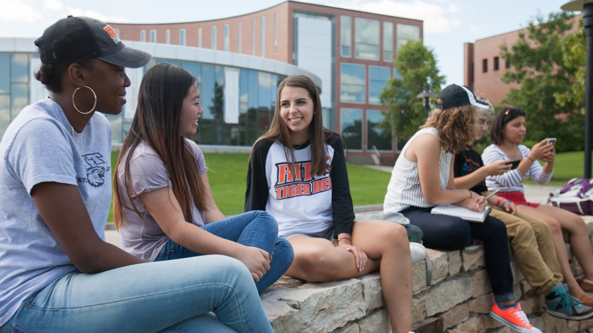 Students talking outside of the Simone Center building.
