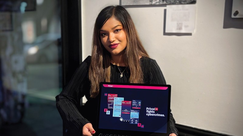 Nunhaz Minhaz displaying her cybercrime victim website on a laptop