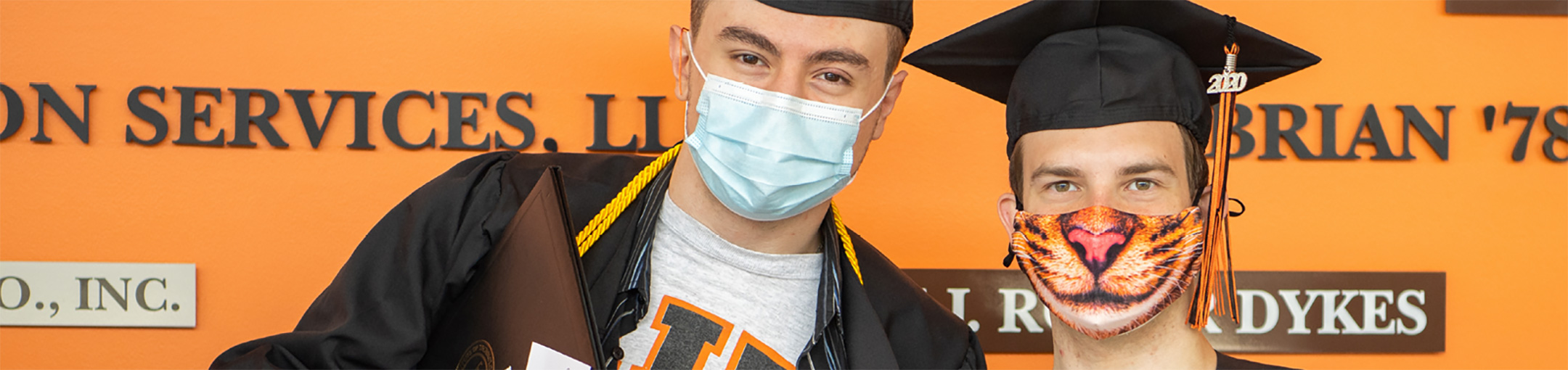 2 students wearing masks at graduation.