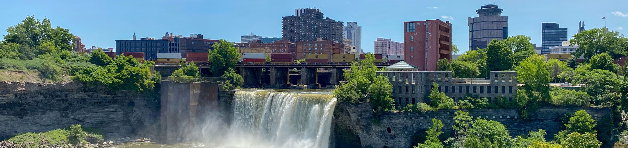 One of the waterfalls in Rochester with the Rochester skyline in the background.