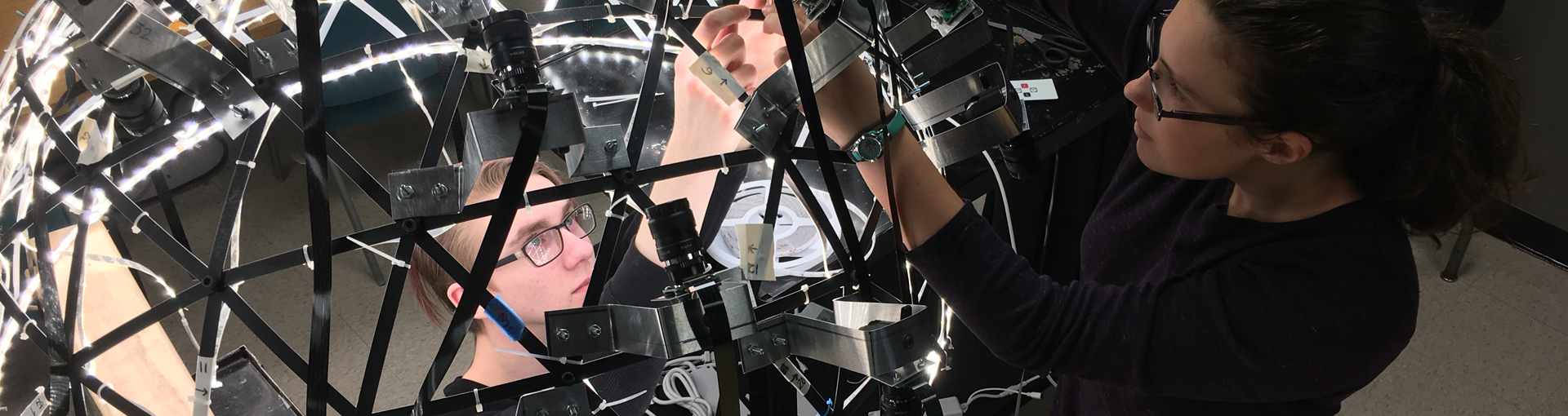 two female students working on dome-shaped imaging system