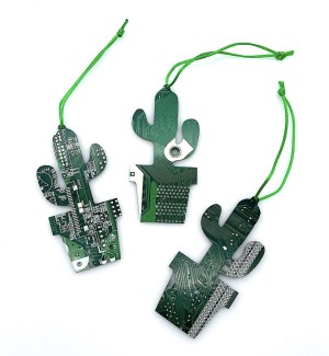 Three green ornaments shaped like a cactus in a pot made of cut circuit board hung on a green string.
