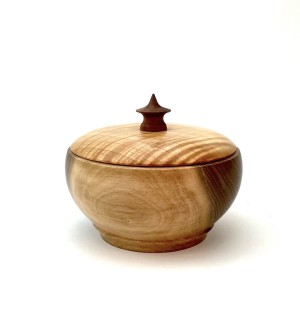 Round lidded bowl with decorative finial made from variegated dark and light wood.