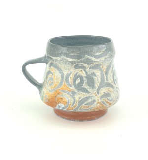 Ceramic Mug with damask patterns of white and grey on orange and blue grey background with deep grey interior, rim, and handle.