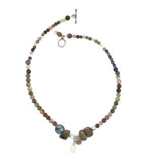 a necklace of strung smoky-hued polished round beads with small silver charms and a toggle clasp.