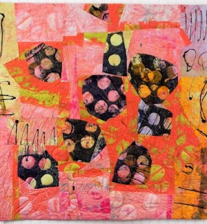 a painterly fabric quilt with a cluster of bulbous black and white dotted forms floating on a coral pink background.
