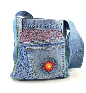 a blue jean fabric shoulder bag with multi colored embroidery embellishment.