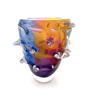 irregular round and funnel shaped glass bowl with protruding elements featuring yellow, blue, and purple color swaths that blend together. 
