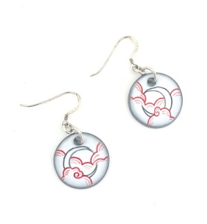 a pair of round white ceramic dangle earrings with an illustration of a present moon in the clouds.