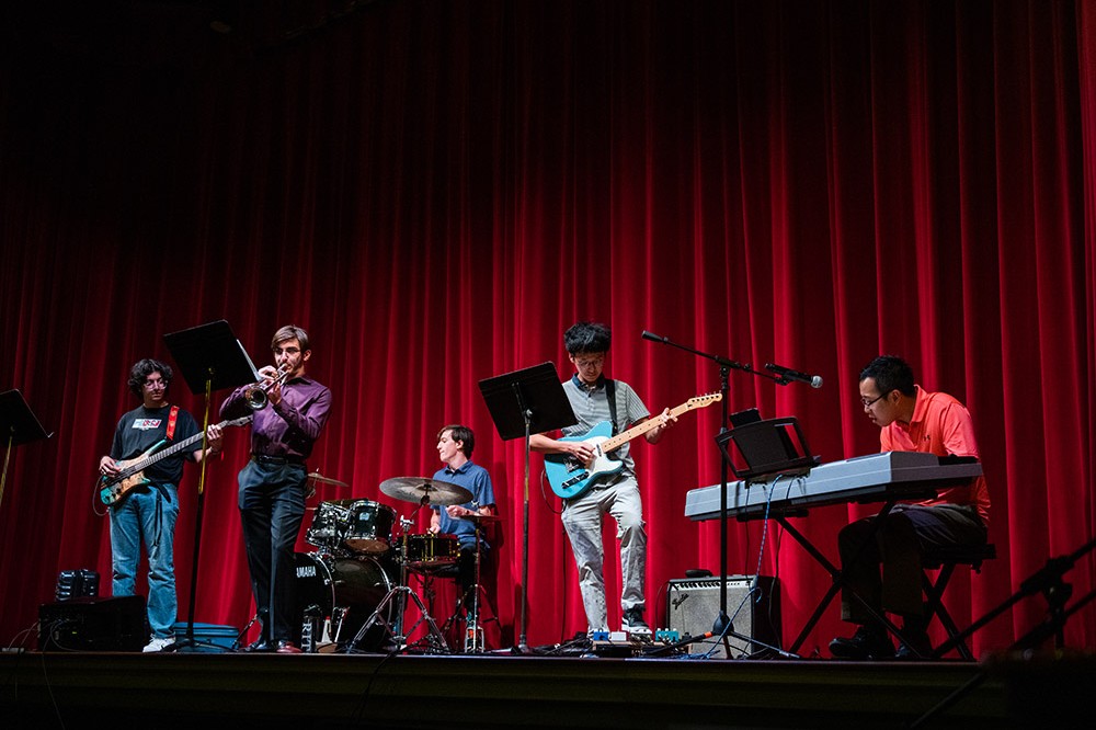 five-piece jazz ensemble performing on stage.