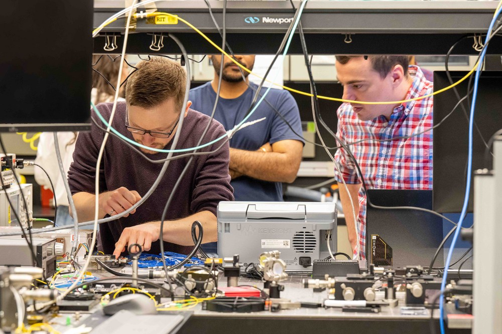 three men working in an electronics lab.