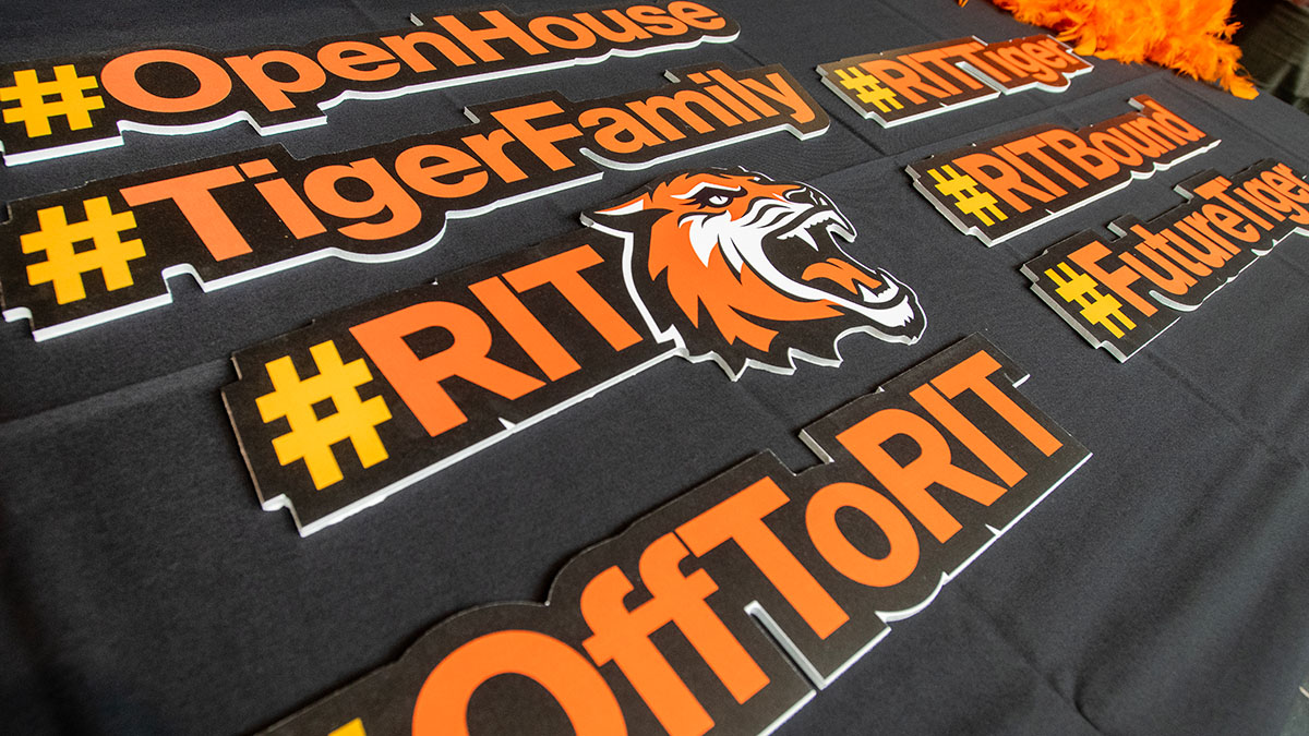 A table decorated with several hashtag signs like #R I T Tiger and #FutureTiger in R I T colors.