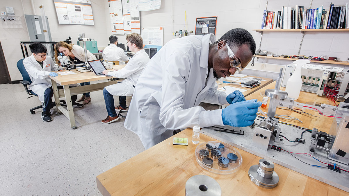 Researchers in lab coats collaborating on experiments in a laboratory with specialized equipment.