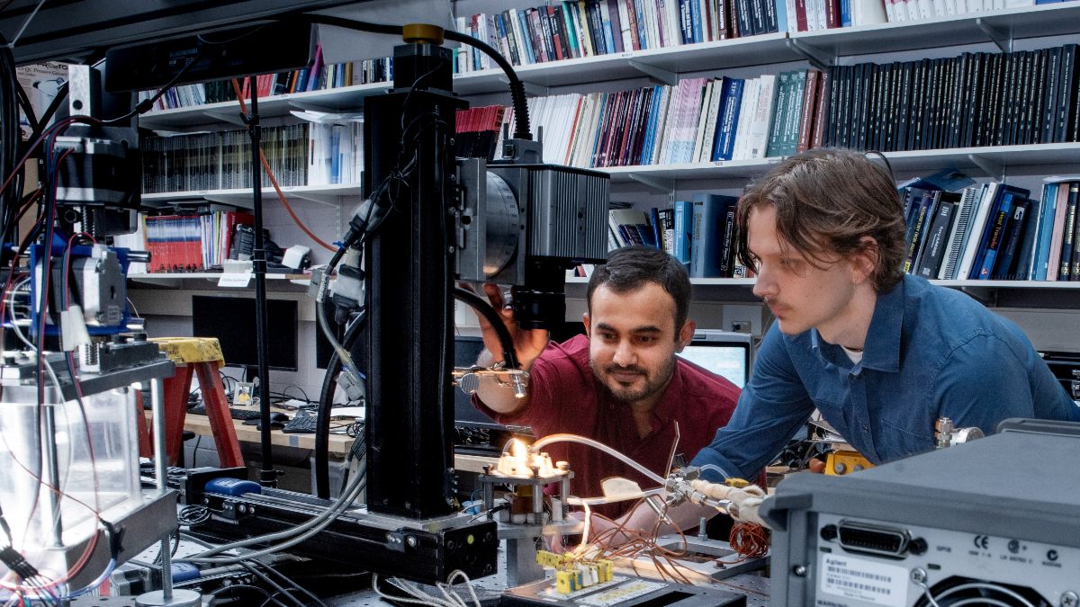 two researchers working with electrical equipment.