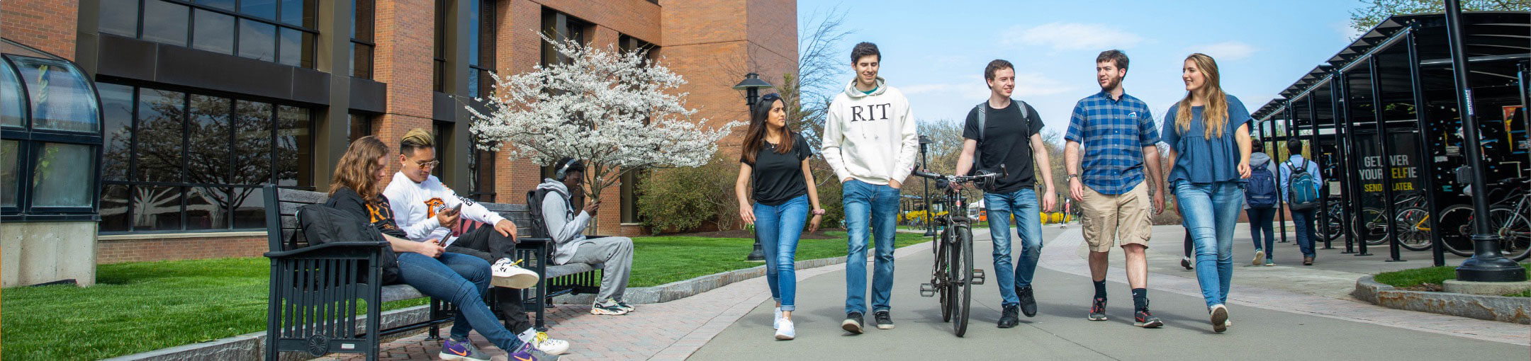 A group of five RIT students walking on campus.