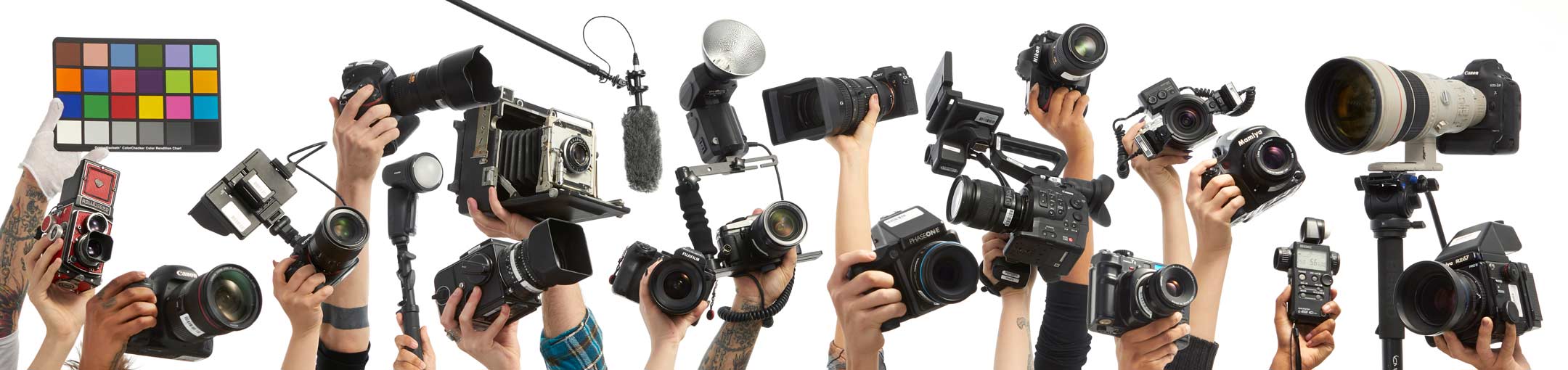 Different cameras being held up by people's hands on a white background