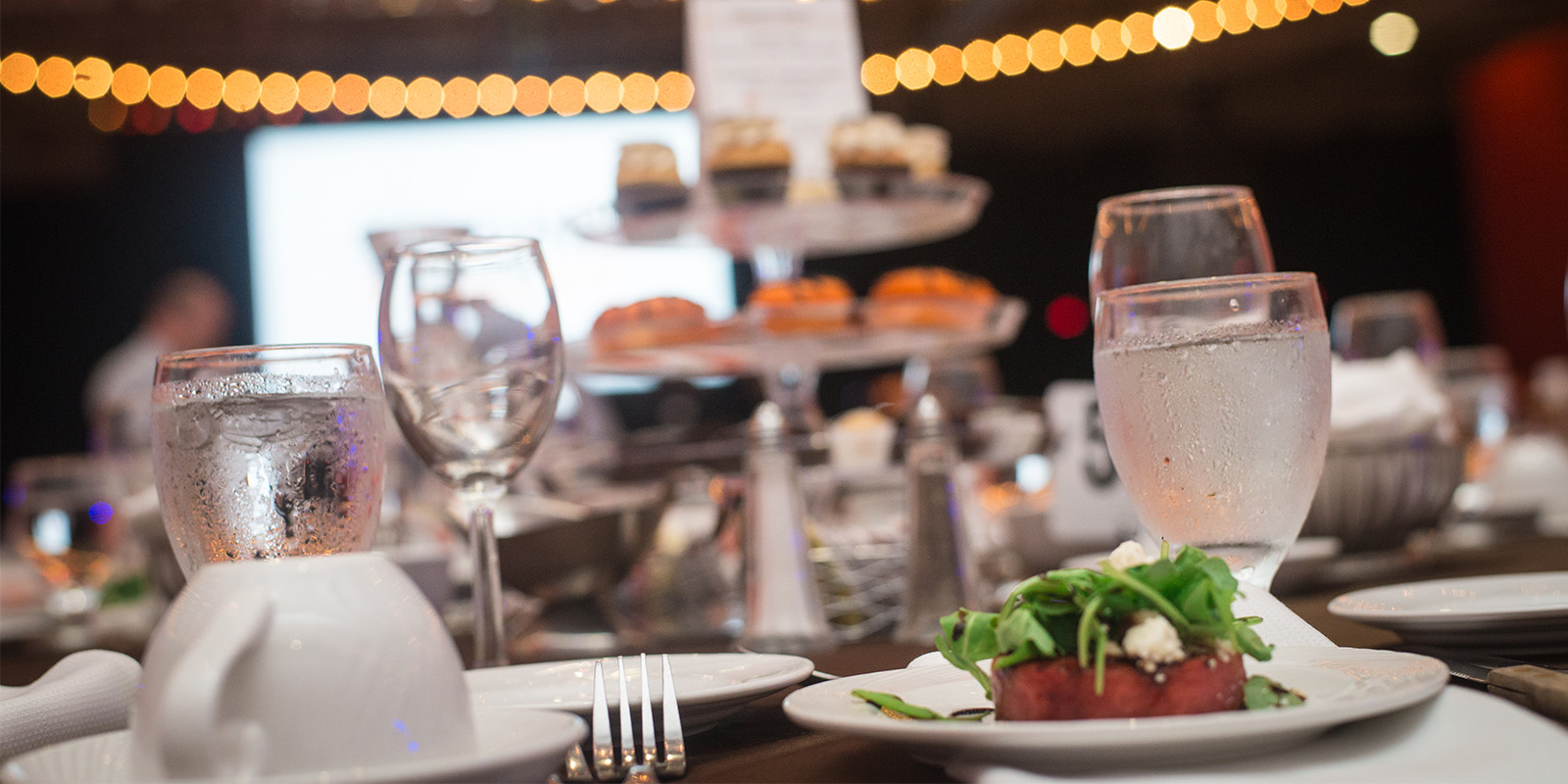 ﻿Table with glasses of water and a plate with food on it