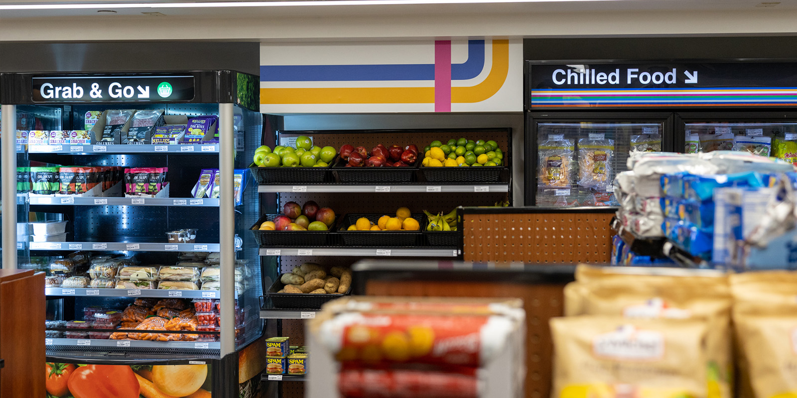 ﻿Interior of a convenience store with shelves of fresh fruit and chilled food