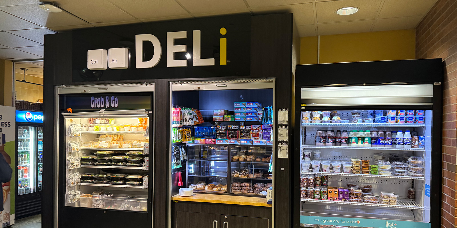 ﻿A deli featuring a refrigerator and a freezer, showcasing various food items and beverages for customers