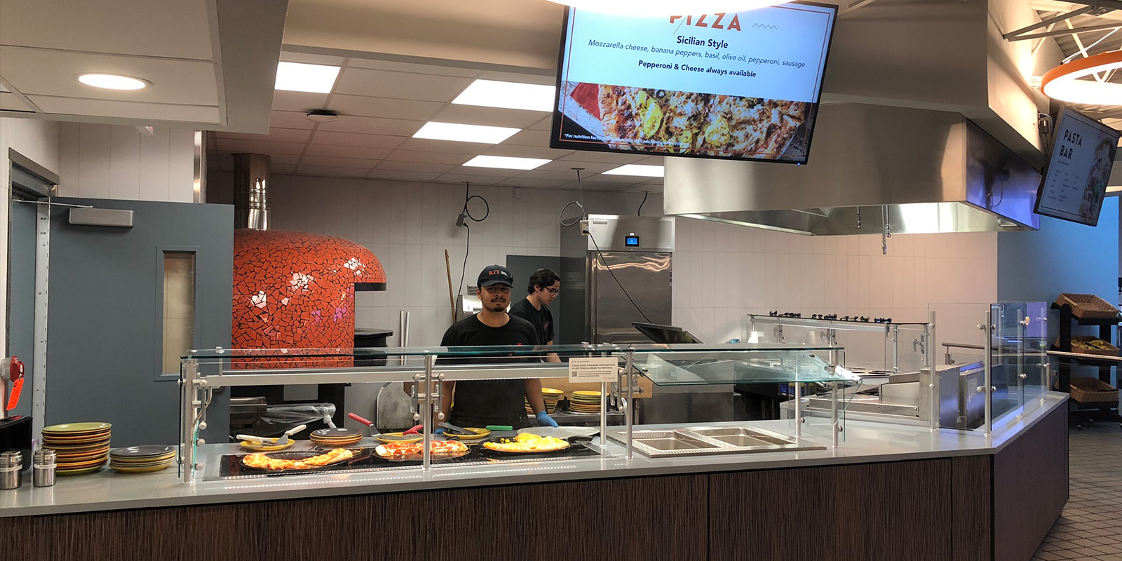 ﻿An employee standing at the pizza station