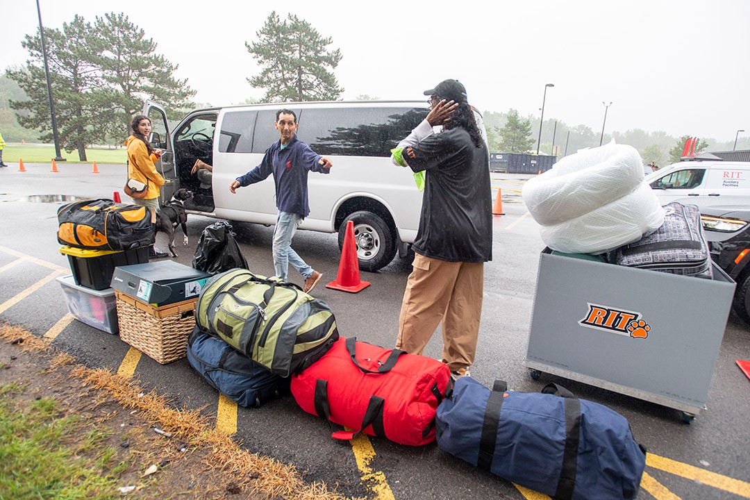 A student and her father moving in with the help of student orientation leader