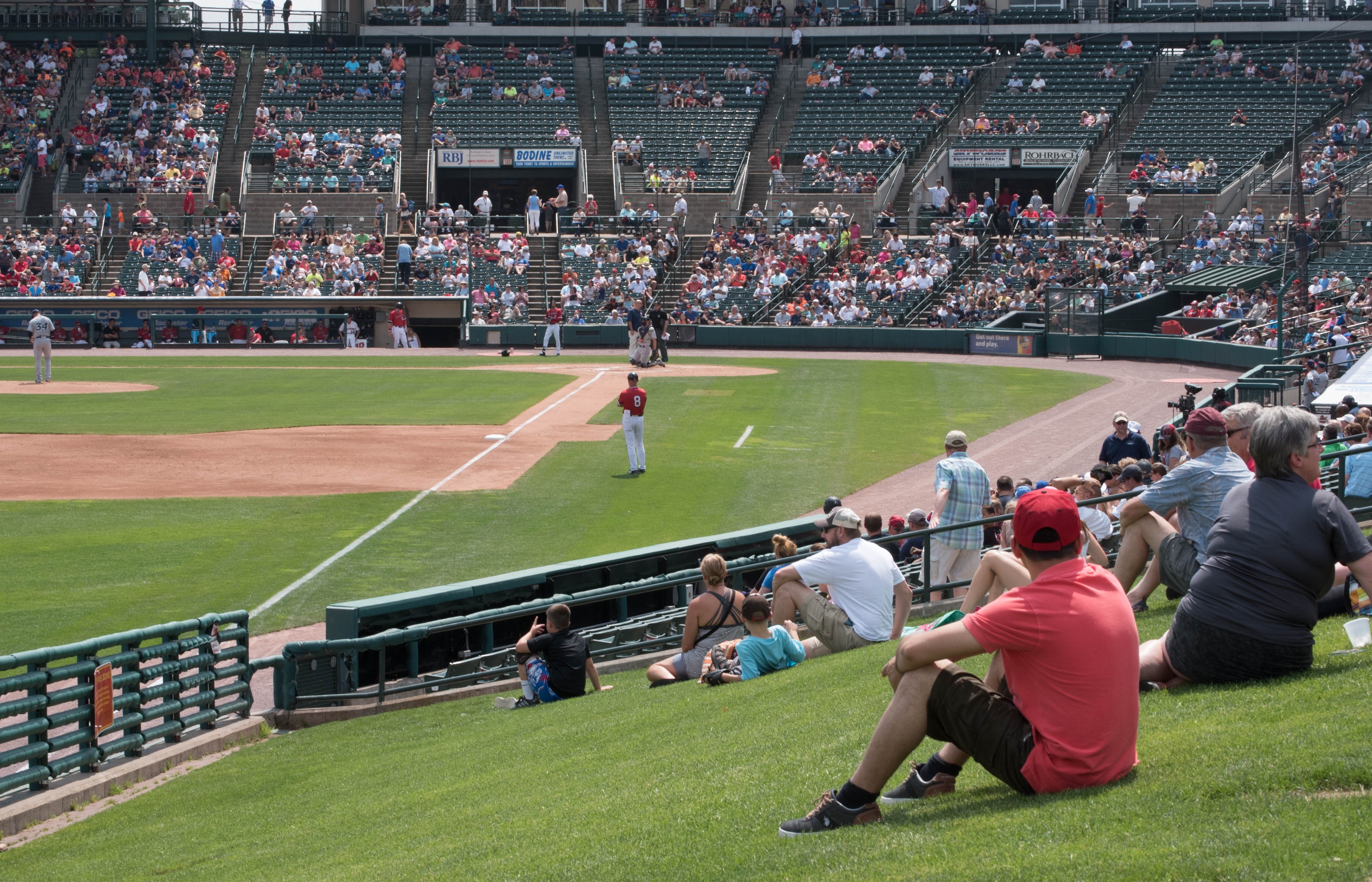 Fans seated on a hill cheering on the Rochester Red Wings