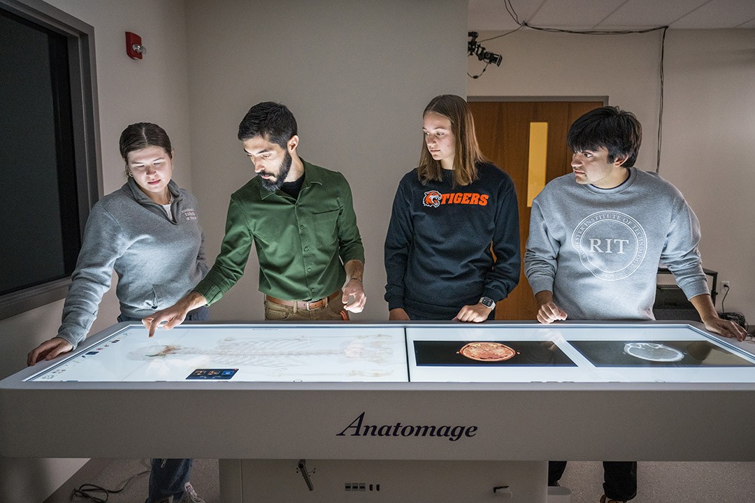 A group engaged in an interactive session around an Anatomage table, exploring detailed digital anatomy visualizations.