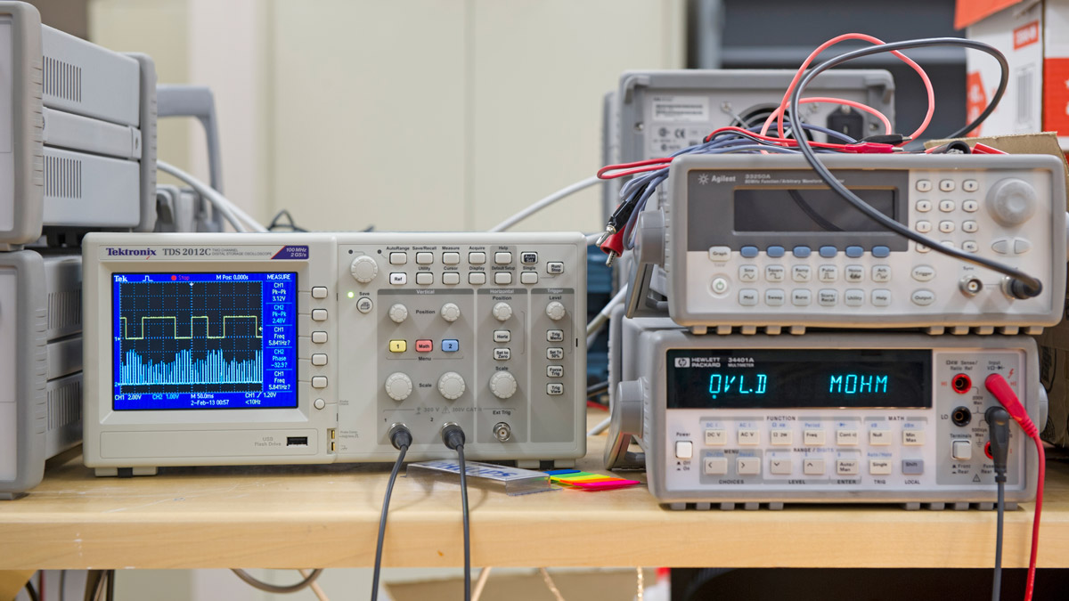 Close up of electrical equipment with displays, several buttons, and connected wires.