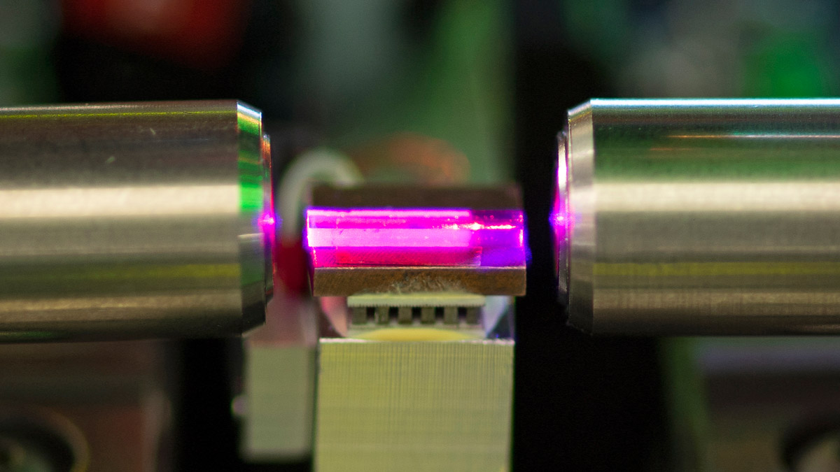 A closeup of a bright pink object inside microsystems engineering equipment.