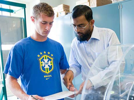 Professor and student reviewing a piece of paper in a lab