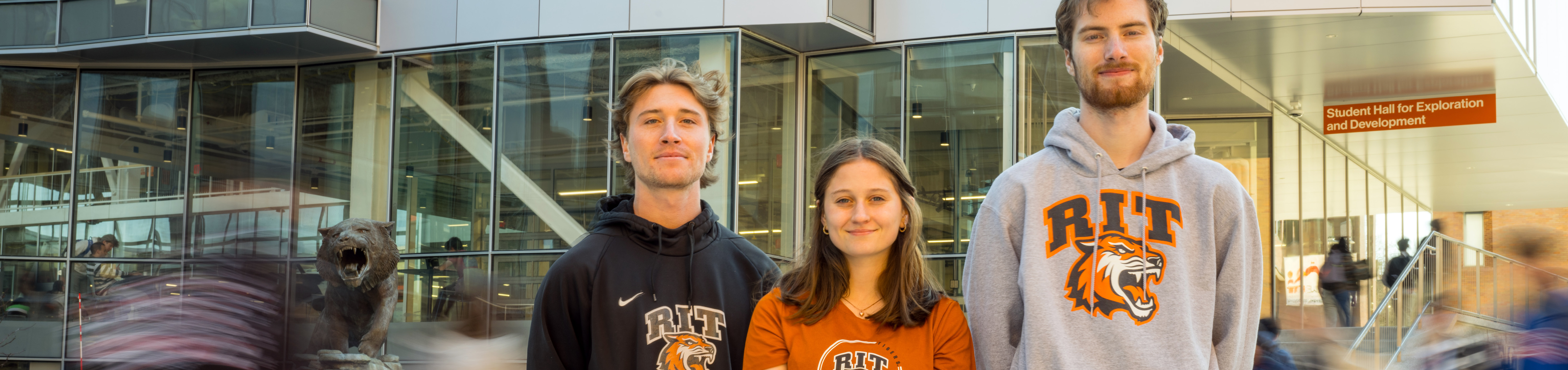 three RIT students standing outside the SHED building