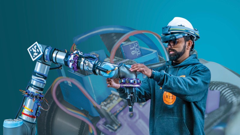 Doctoral student Karthik Subramanian wearing augmented reality goggles that create a digital twin of the environment and display information to help keep people safe around collaborative robots