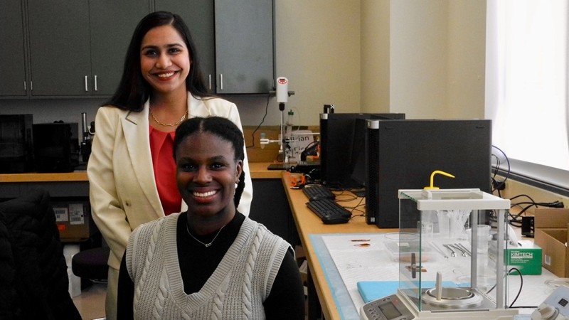 Leila Daly is seated in front of Professor Krittika Goyal in an engineering lab.