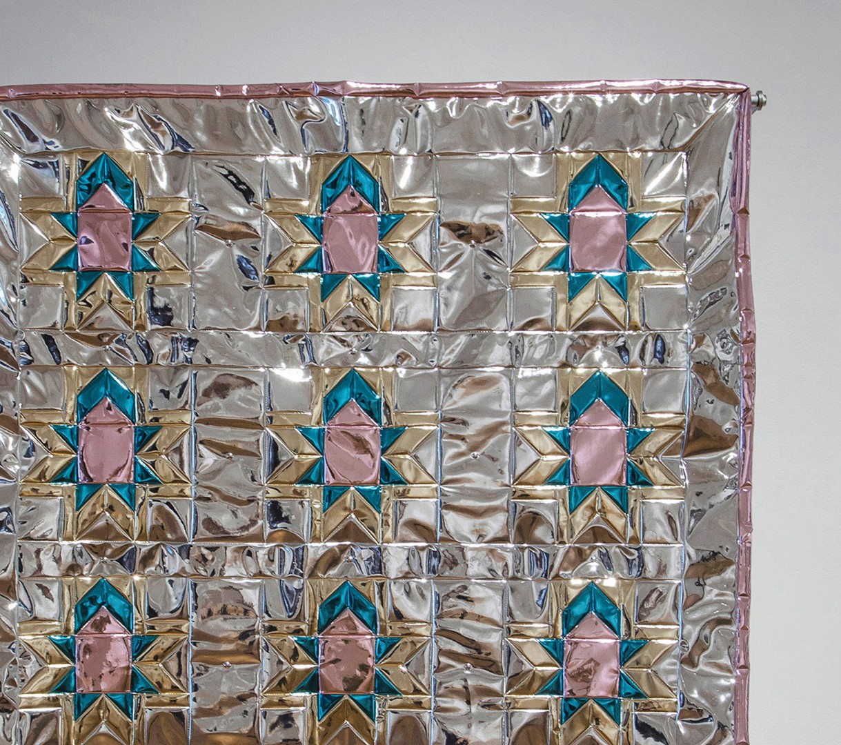 A shiny art installation that has the appearance of a quilt.