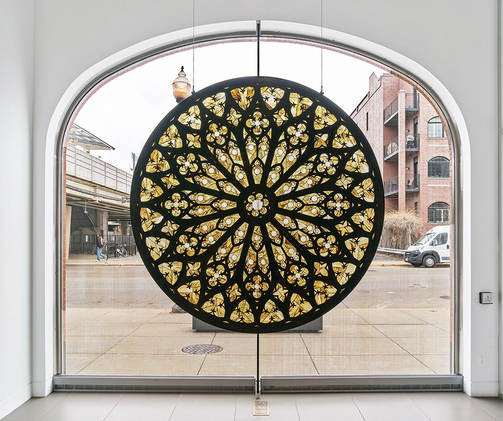 A glass installation in front of a gallery window.