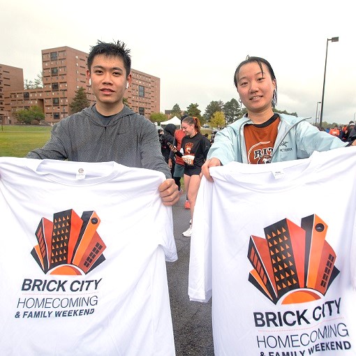 Students holding Brick City T-shirts