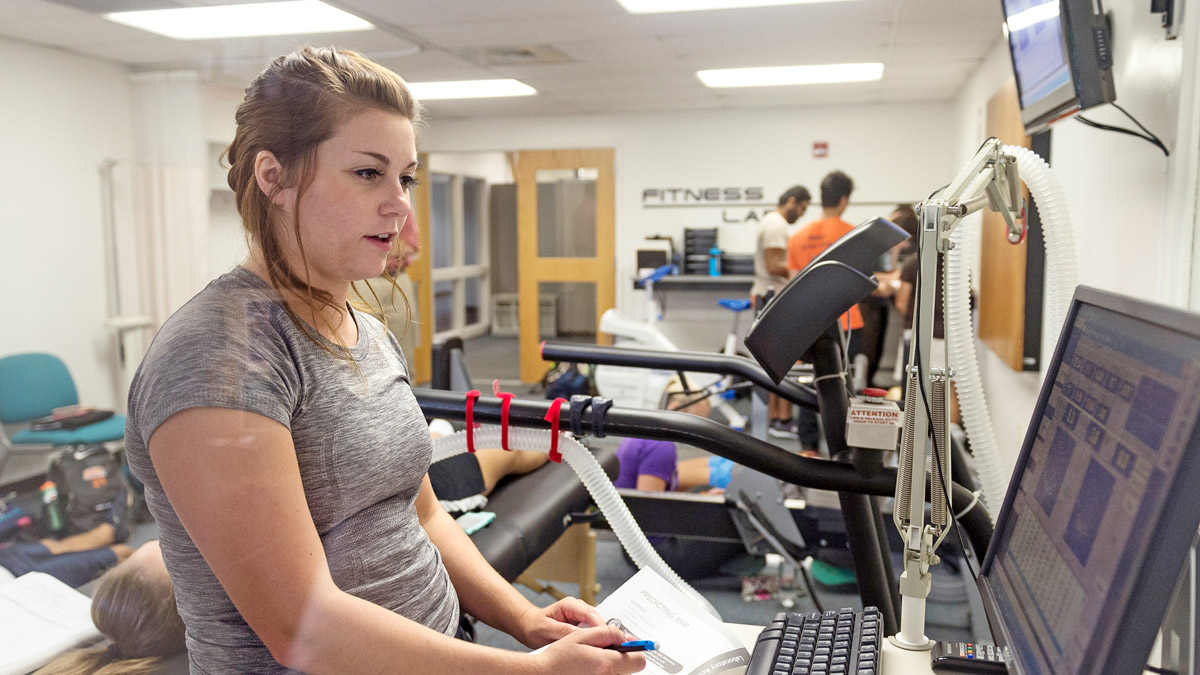 Student in exercise lab working at a computer.