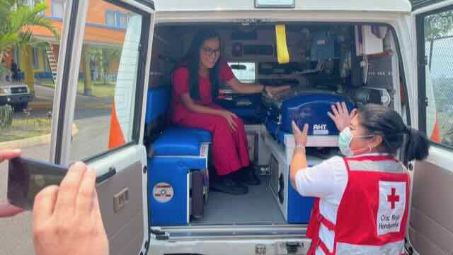 two women working in rear of ambulance