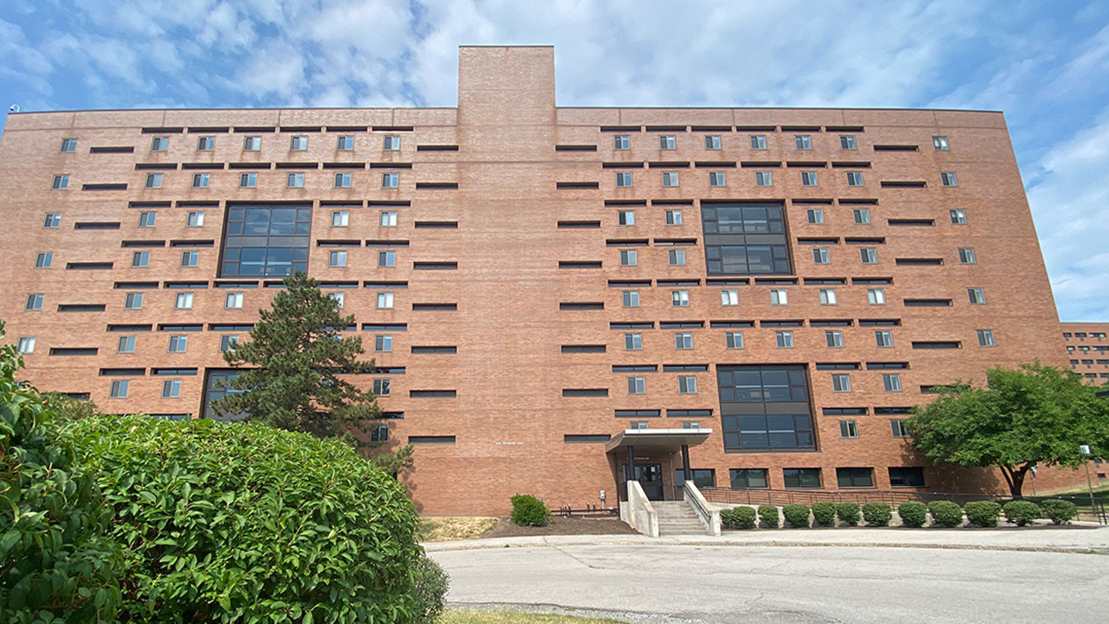 courtyard in middle of residence halls with stone sculpture and flowers