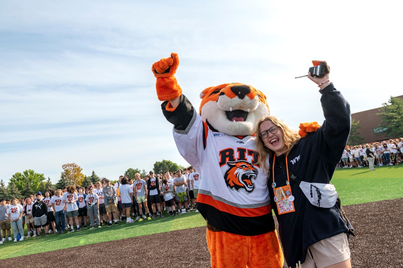 staff member posing for a happy picture with Ritchie during Freshmen Orientation week