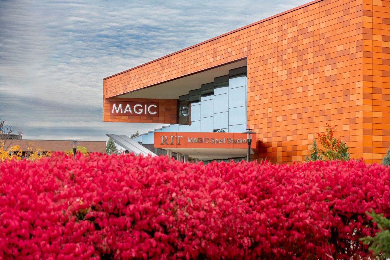 view of the MAGIC studios with bright red burning bush plants in the foreground