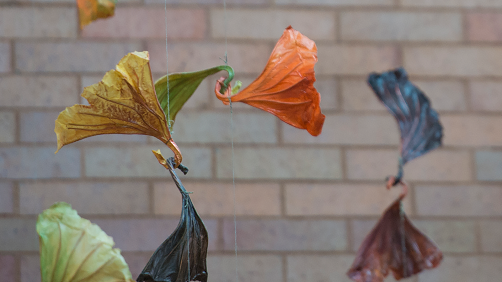 hanging art in foreground, brick wall in background