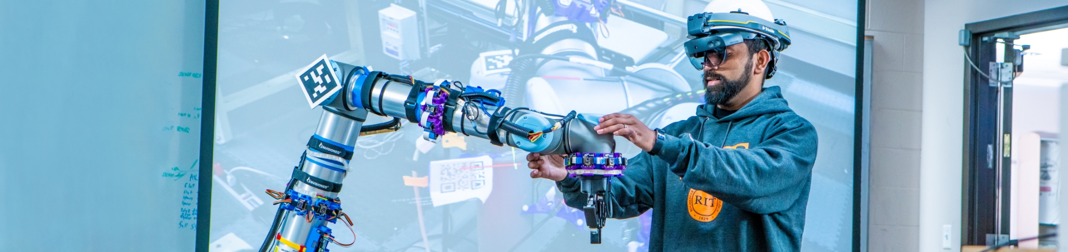 A man interacting with a robotic arm.