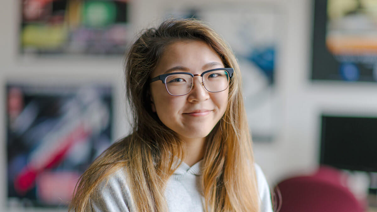 Portrait of a long-haired student wearing glasses.