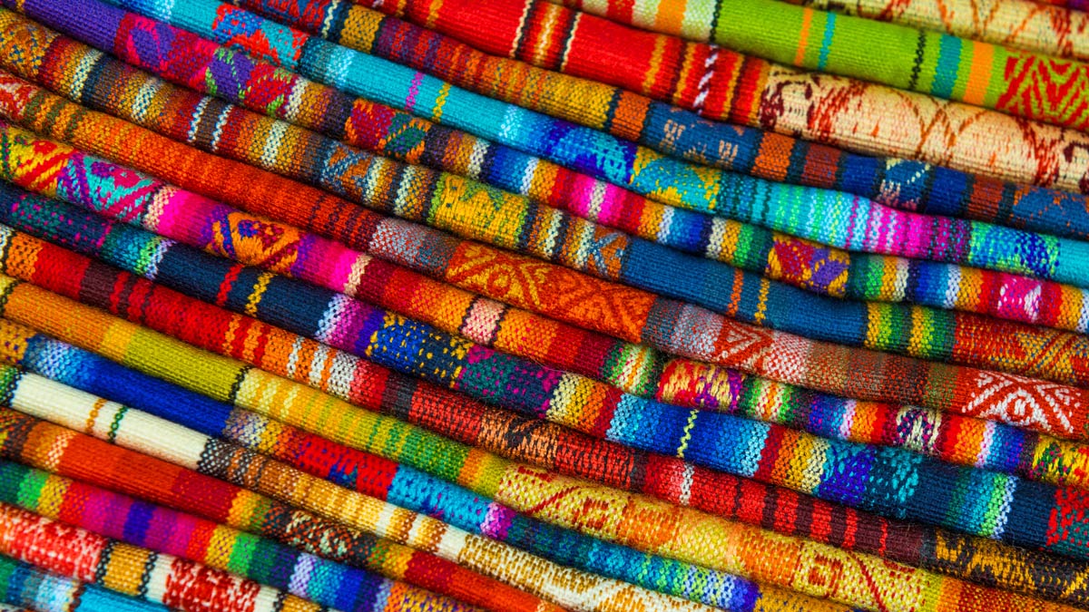 Close up of many different, colorful knit fabrics.