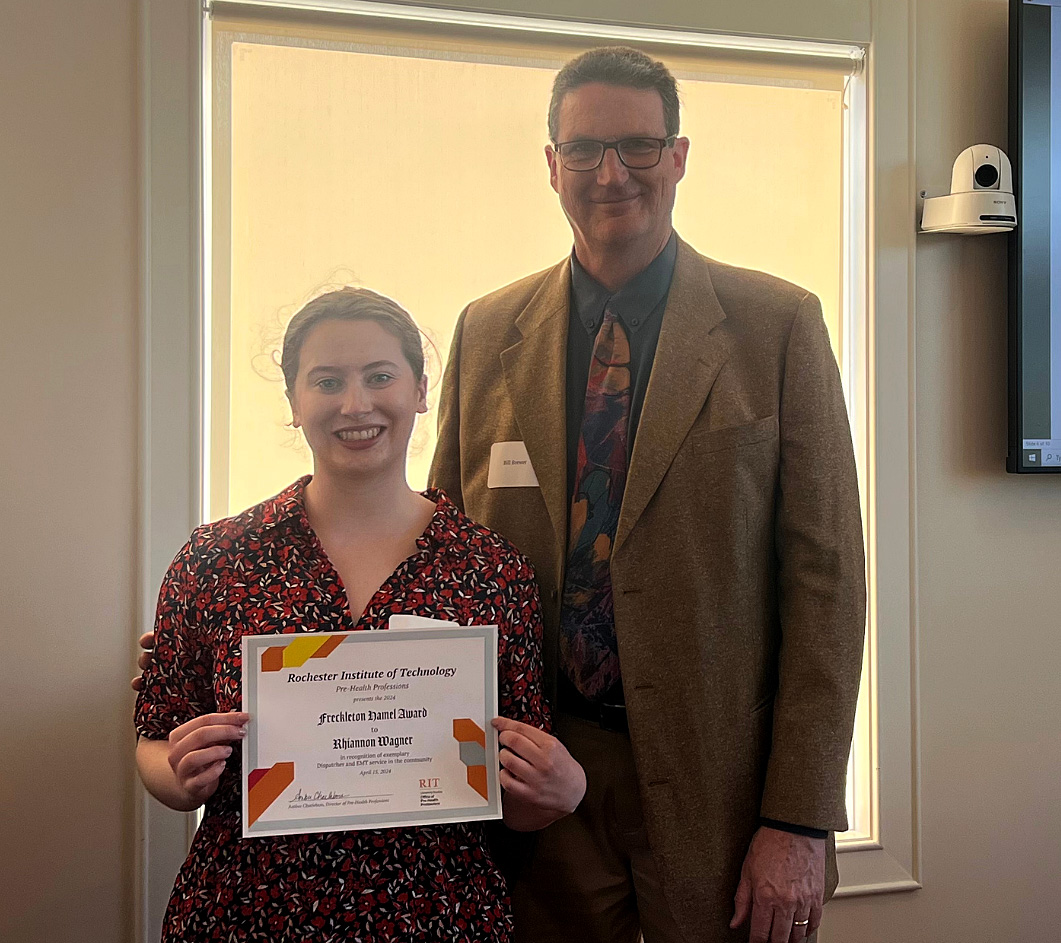 Rhiannon Wagner, EMT-B holds an award with Dr. Bill Brewer.