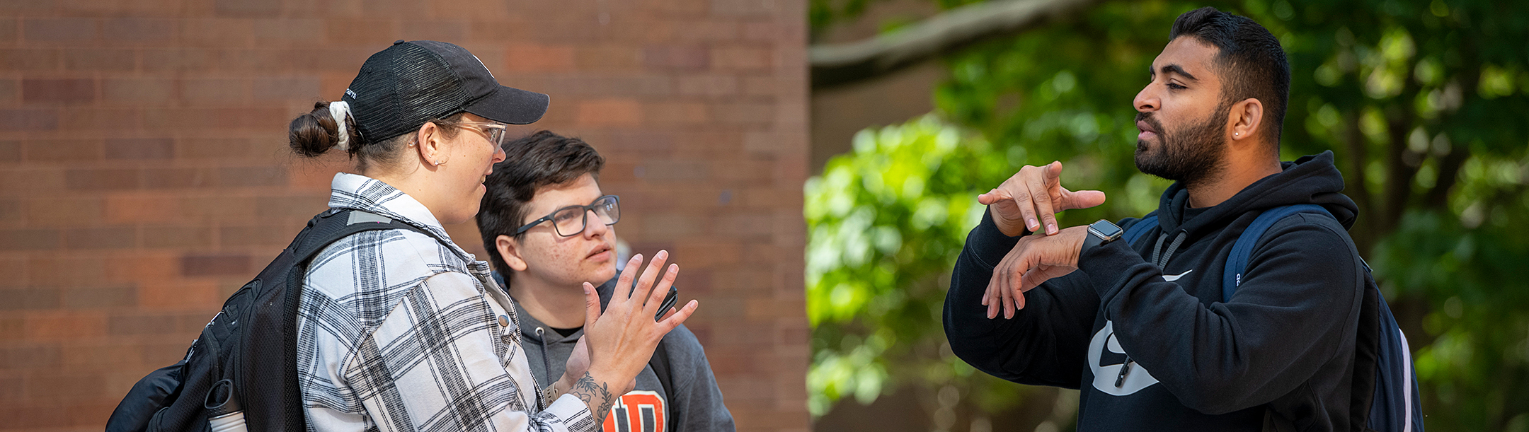 Three students signing with each other