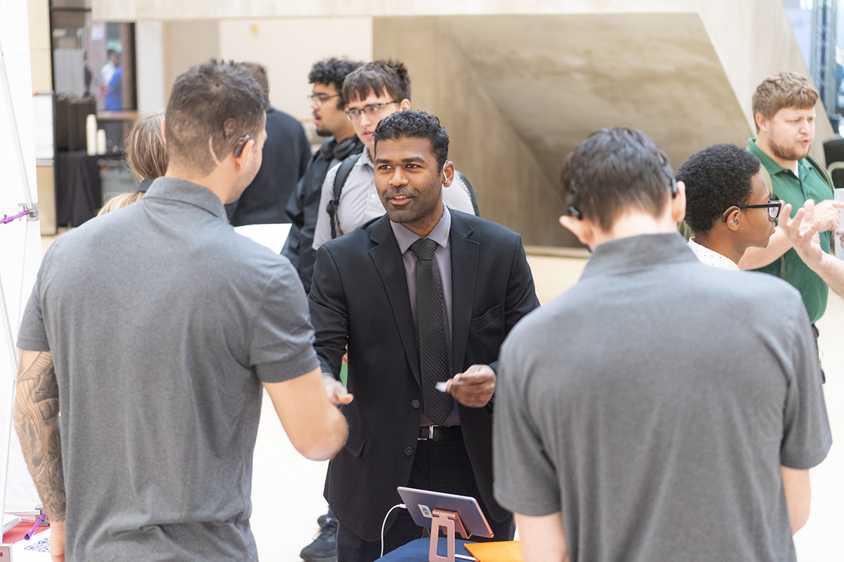 Photo of male student shaking hands with the employer at career fair event