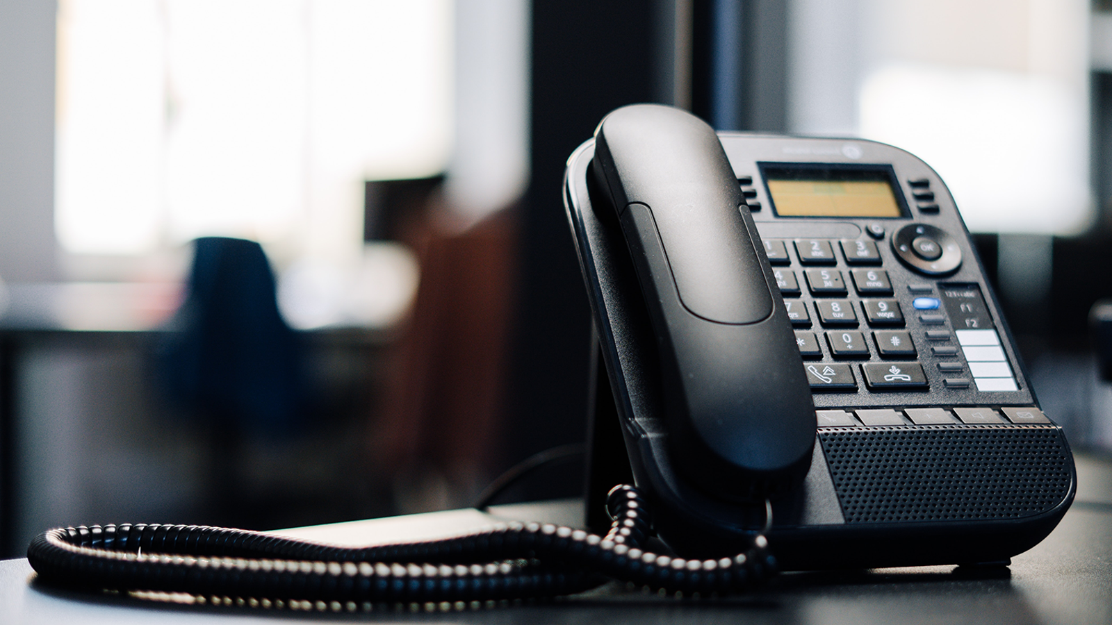 A telephone positioned on a desk, symbolizing communication and connection in a professional environment.