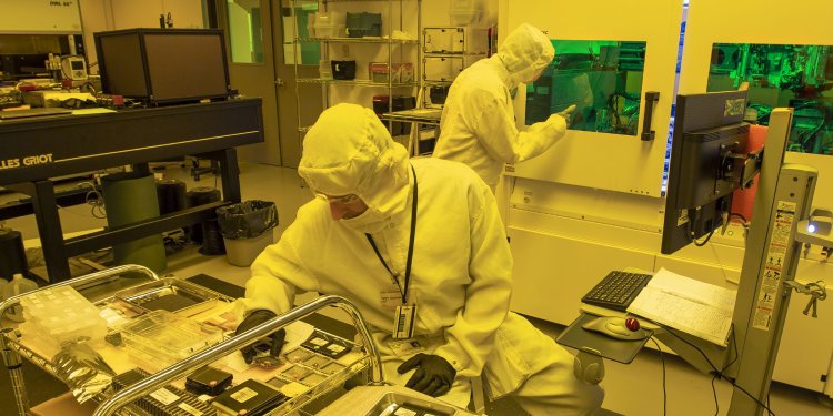 A group of students wearing masks using a cordless drill.